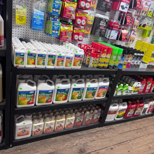 A variety of gardening and pest control products displayed on shelves in a store.
