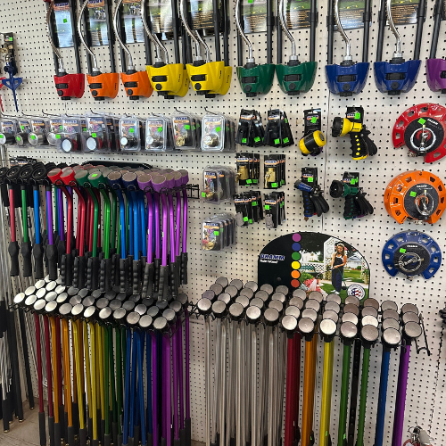 A display of various tools and equipment hanging on a pegboard, including colorful versions of poles, measuring tapes, and other accessories.