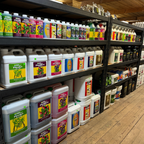 Shelves filled with various bottles of plant nutrients and gardening supplies in a store.