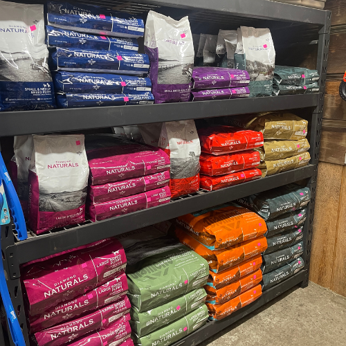 Shelves stocked with various bags of pet food in different colors and sizes.