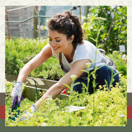 Lawn & Garden SuppliesA woman smiles while tending to lush green plants in a vibrant garden. She wears a white shirt, apron, and gloves, conveying a joyful, peaceful mood.